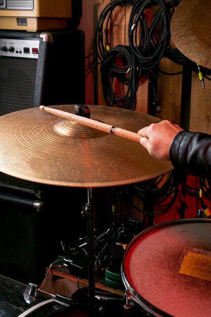 Hand playing on cymbal with stick