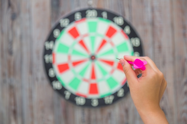 Hand pointing a dart to a target