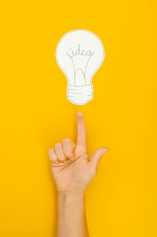 Hand pointing to a lighten bulb