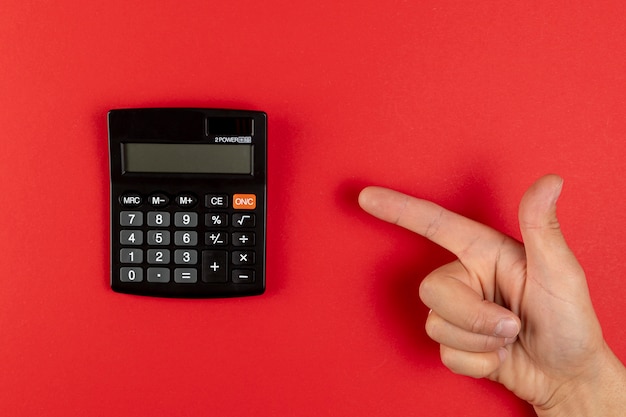 Hand pointing to a mini calculator