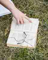 Free photo hand pointing at open book on grass