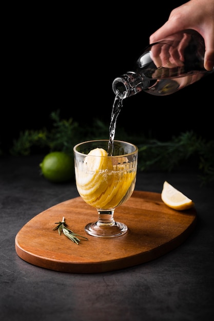 Hand pouring champagne with lemon slice