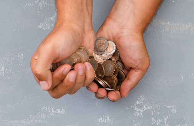 hand pouring coins into another one.