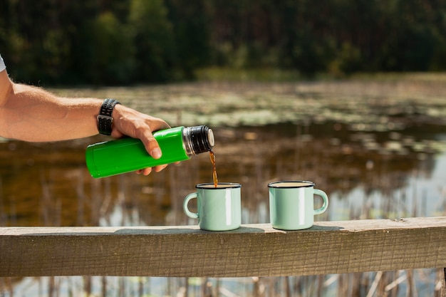 Hand pouring drink in cups