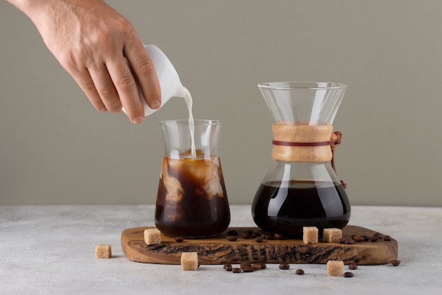 Free photo hand pouring milk into coffee cup