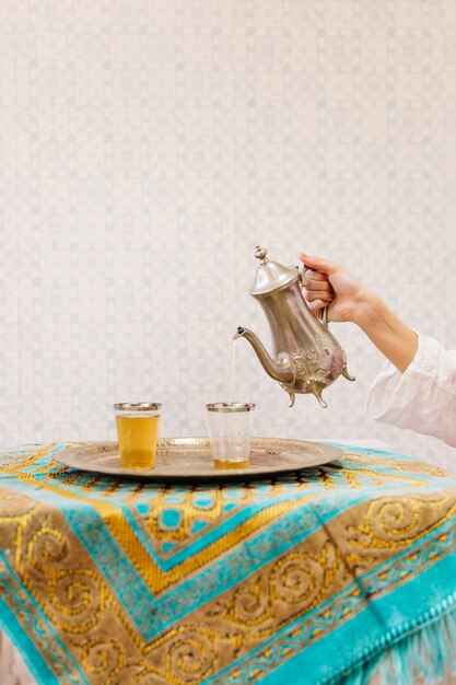 Hand pouring tea into glass