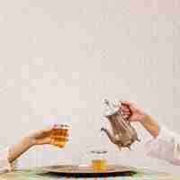 Free photo hand pouring tea into glass