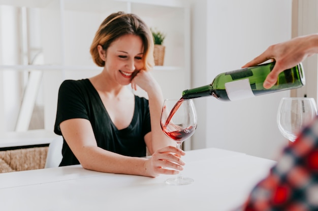 Free photo hand pouring wine for girlfriend