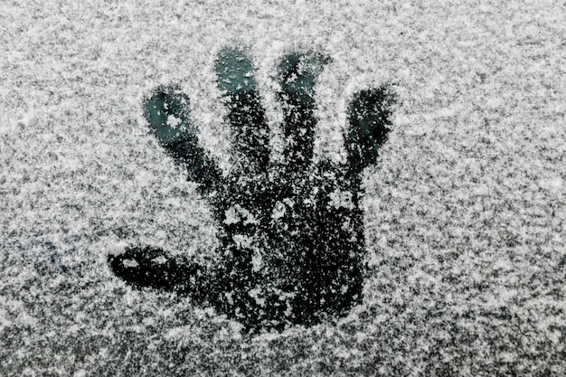 Free photo hand print on glass in winter