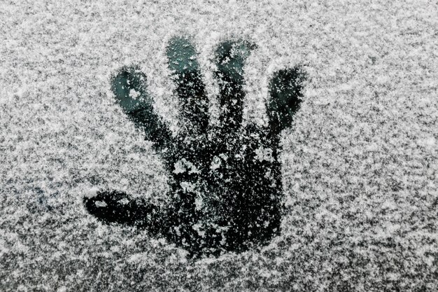 Hand print on glass in winter