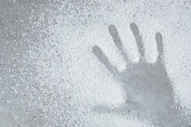 Hand print left in a pile of coconut powder on marble surface