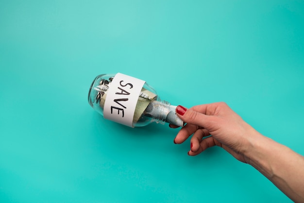 Hand putting money into jar