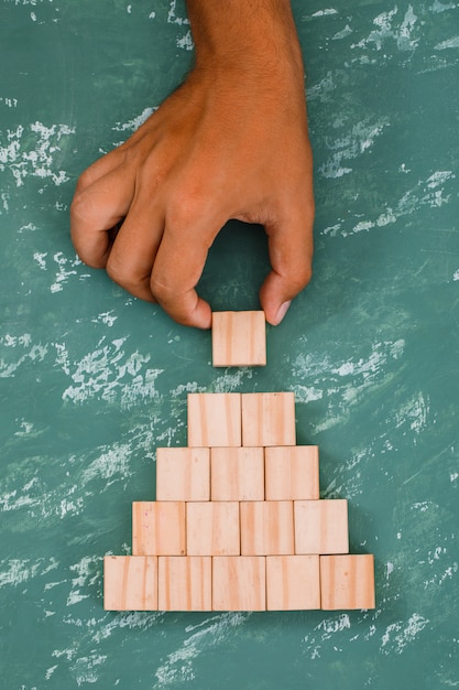 hand putting and stacking wooden cube.