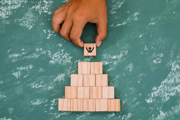 hand putting and stacking wooden cubes