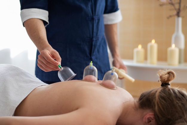 Hand putting suction cups on woman's back