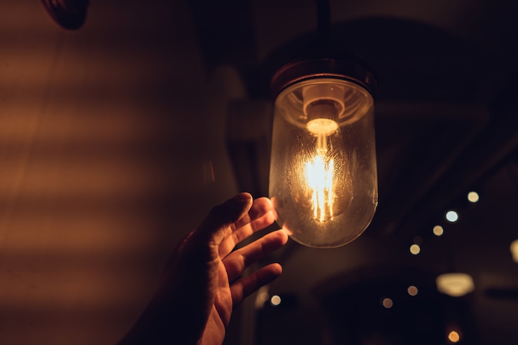 Free Photo hand reaching for a vintage light bulb.