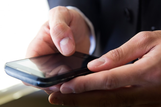 Hand's detail of Businessman  using a samrtphone