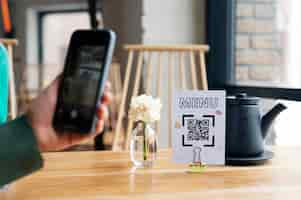 Free photo hand scanning qr code at restaurant