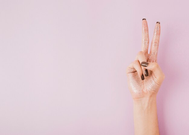 Hand showing peace sign on copy space background