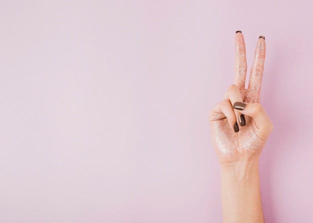 Hand showing peace sign on copy space background