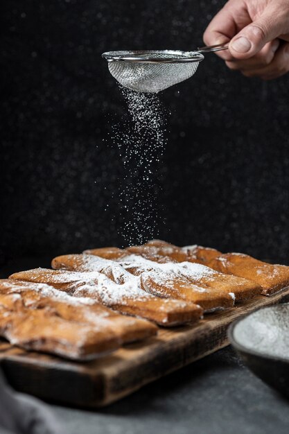 Hand sieving powdered sugar on desserts