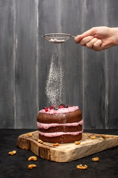 Hand sieving powdered sugar on top of hands