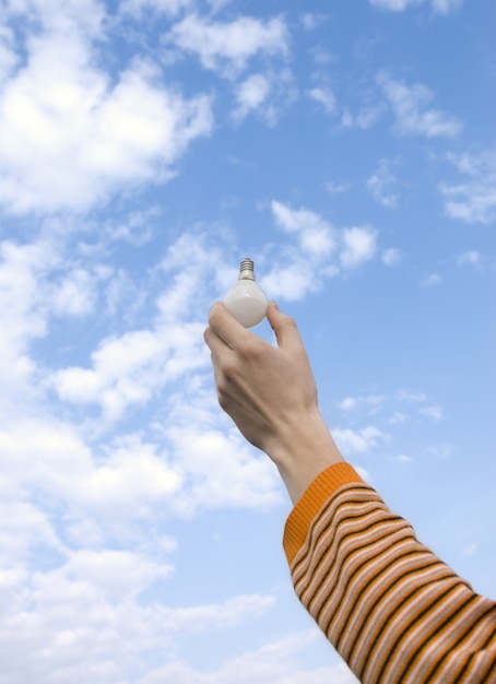 hand in the sky holding idea lightbulb