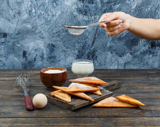 木の板のワッフルに小麦粉を手で振りかける