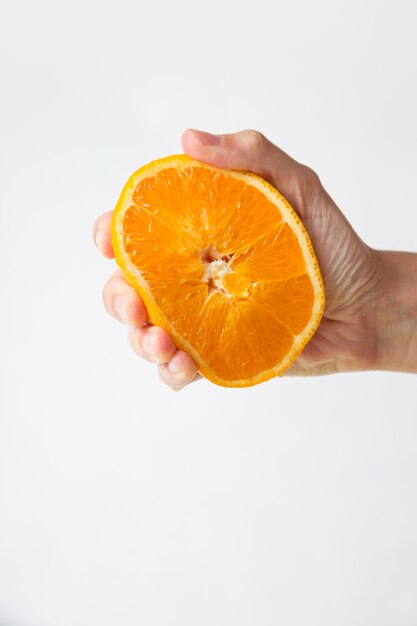 Hand squeezing orange half for juice