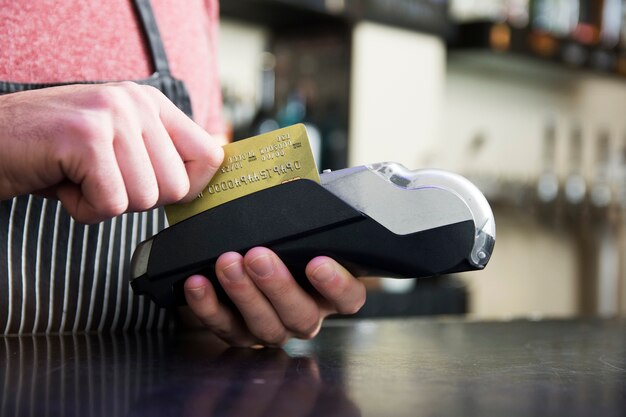 Hand swiping credit card on card reader device