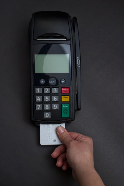 가 게에서 신용 카드를 강타하는 손. 신용 카드와 은행 터미널 여성 손. POS 및 신용 카드의 컬러 이미지.