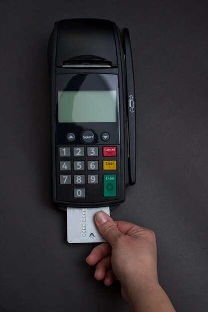 Hand Swiping Credit Card In Store. Female hands with credit card and bank terminal. Color image of a POS and credit cards.