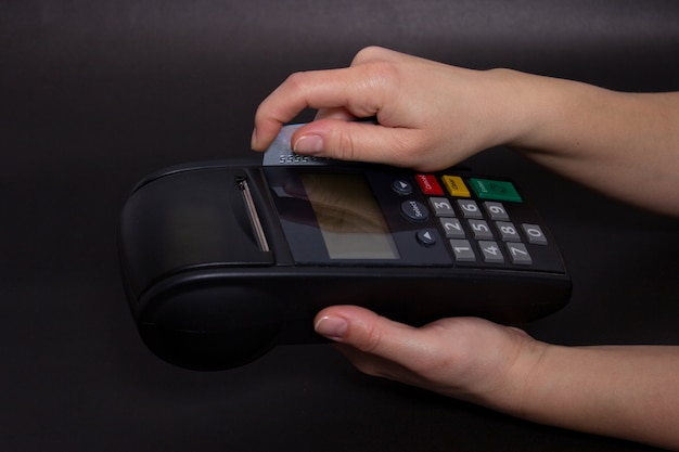 Рука Swiping кредитной карты в магазине. Женщины руки с кредитной карты и банковский терминал. Цветное изображение POS и кредитных карт.