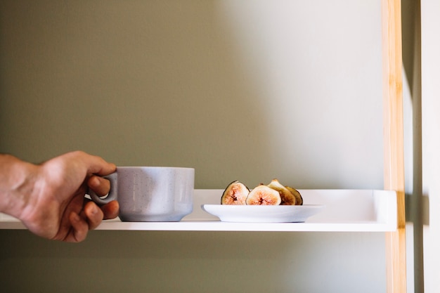 Hand taking cup from table