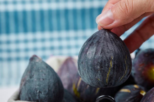 Hand taking a fig from the basket.