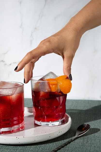 Hand taking negroni cocktail glass