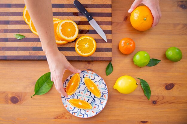 세라믹 접시에서 오렌지 조각을 복용 손