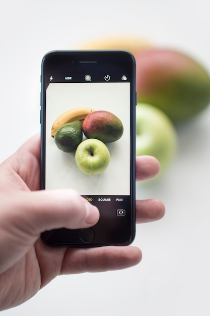 Free photo hand taking shot of fruits