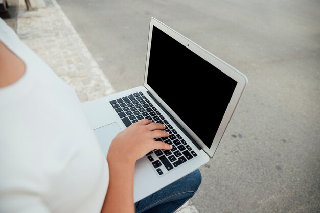 Hand touching laptop keyboard with mock-up