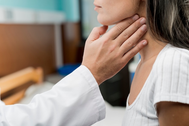 Hand touching throat of patient