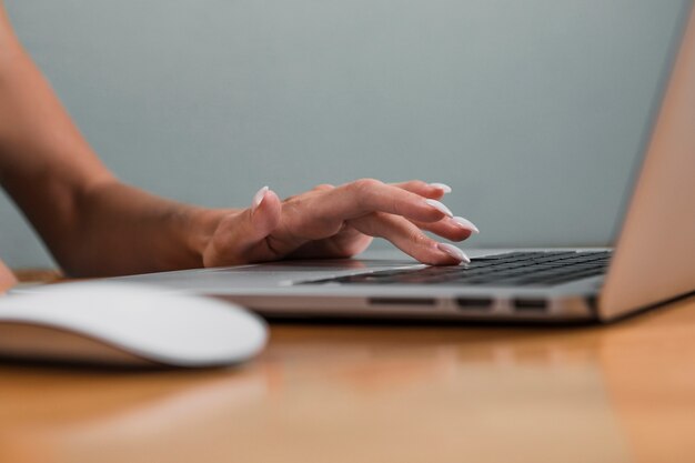 Hand typing on laptop keyboard