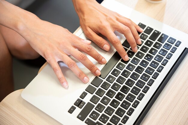 Hand typing on laptop top view