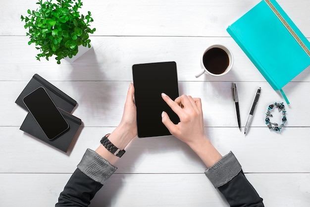 Hand use tablet on desk table top view. Copy space. Flat lay