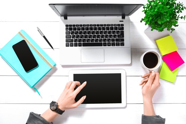 Hand use white tablet on desk table top view. Copy space. Flat lay