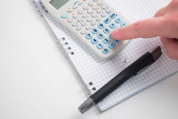 Hand using calculator on desk