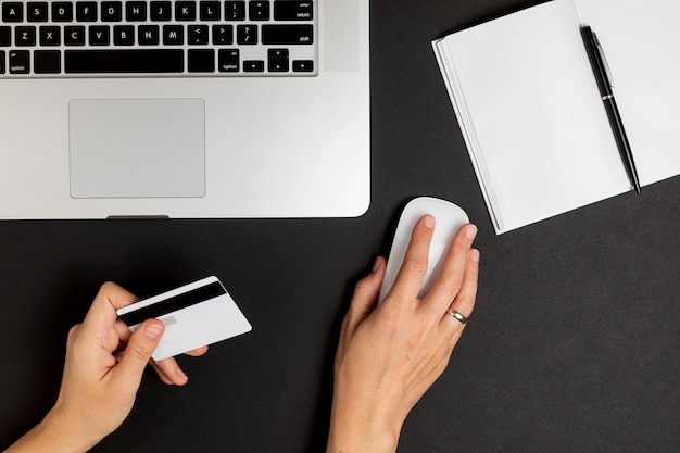 Hand using mouse and holding a credit card