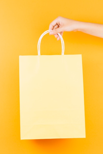 Hand with beige shopping packet