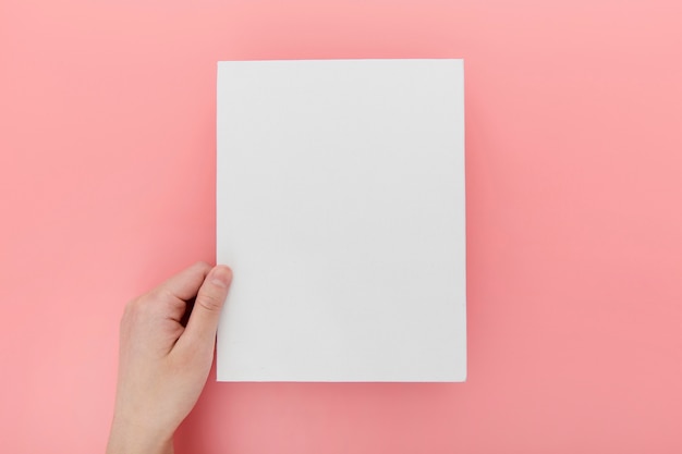 Hand with blank brochure on desk