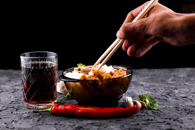 Hand with chopsticks and rice bowl