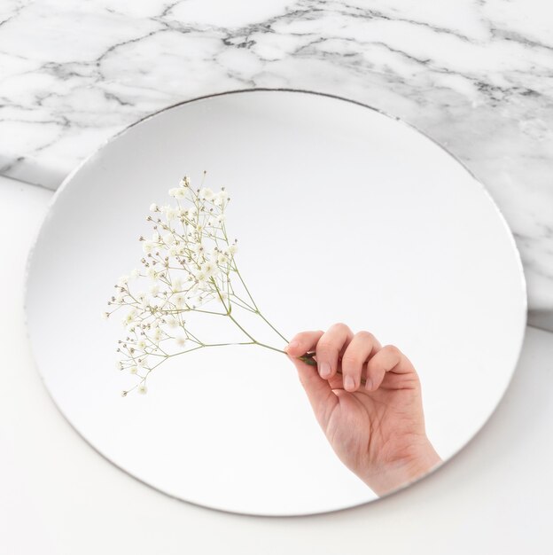 Hand with flowers in mirror